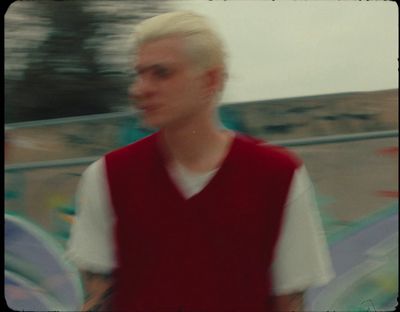 a man with white hair wearing a red vest