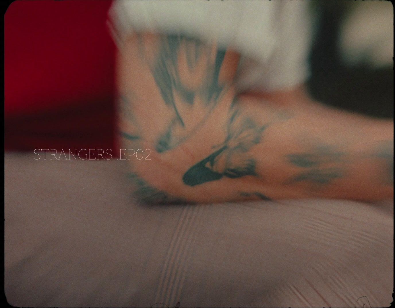 a person with a tattoo on their arm laying on a bed