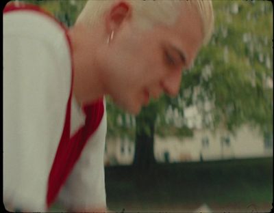 a man with blonde hair wearing a red and white shirt