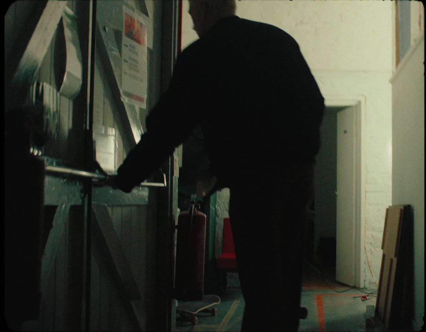 a man standing in a hallway next to a door