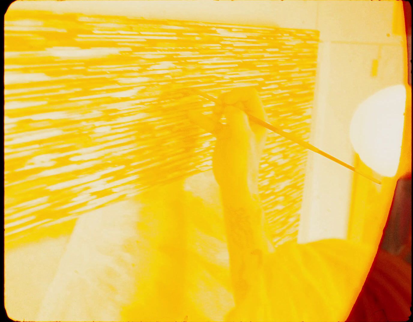 a person holding a toothbrush in front of a yellow wall