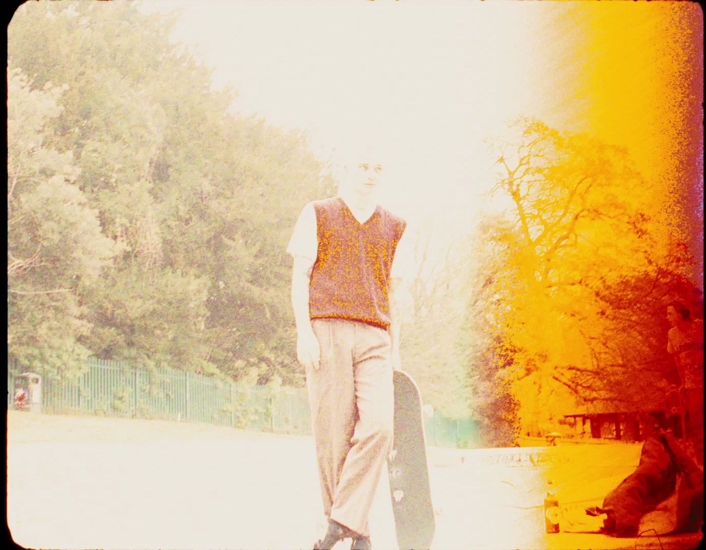 a man holding a skateboard in a park