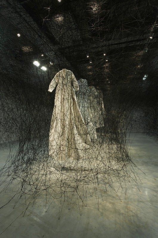 a sculpture of a woman standing in a dark room