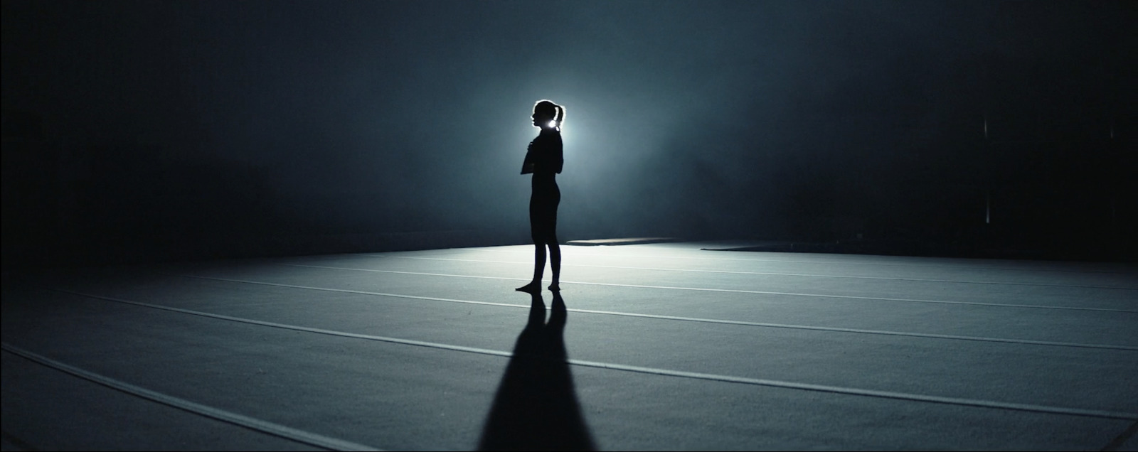 a woman standing alone in a dark room