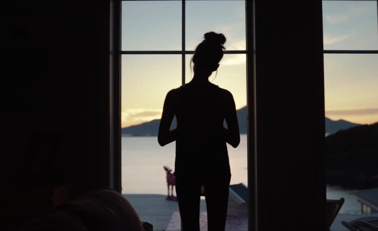 a silhouette of a woman standing in front of a window