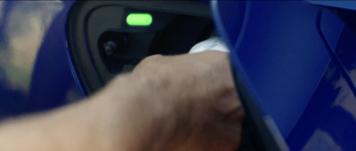 a hand is pressing a button on a blue car