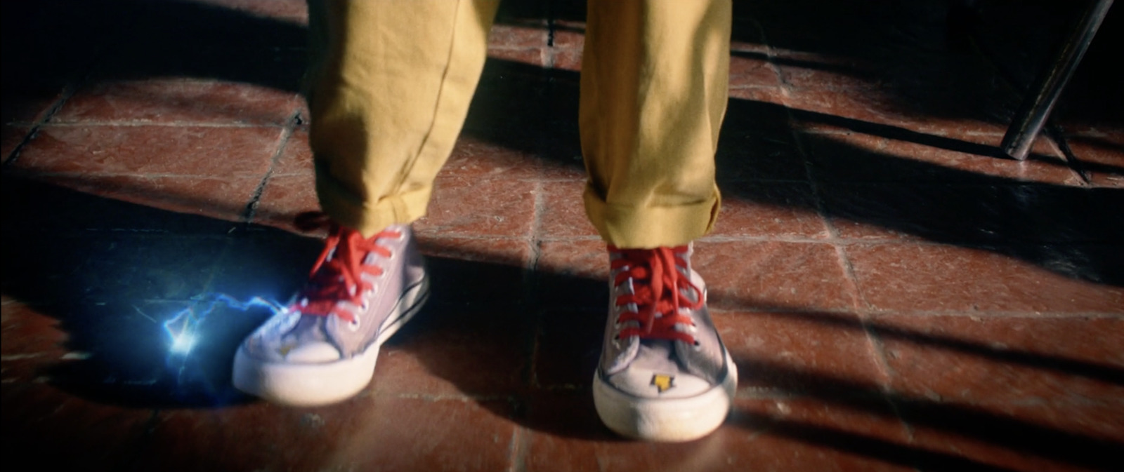 a person with red and white shoes standing on a tile floor