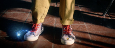 a person with red and white shoes standing on a tile floor