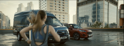 a woman standing next to a van in a parking lot