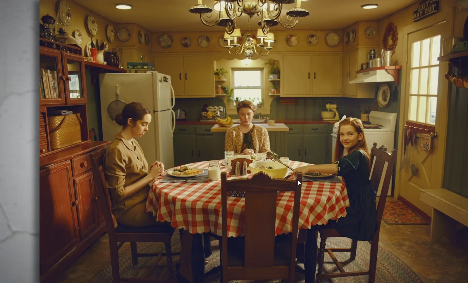 a group of women sitting around a table in a kitchen