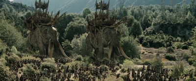 a large group of people standing next to two giant elephants