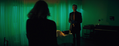 a man standing in a dark room next to a woman