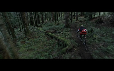 a man riding a bike down a forest trail