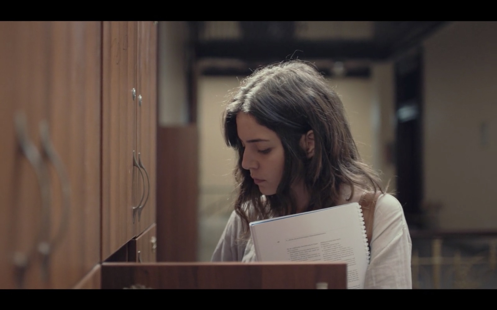 a young girl is holding a book in her hands