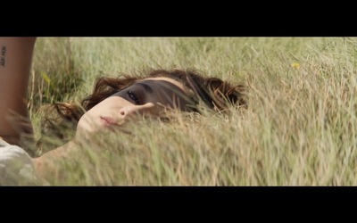 a woman laying in a field of tall grass