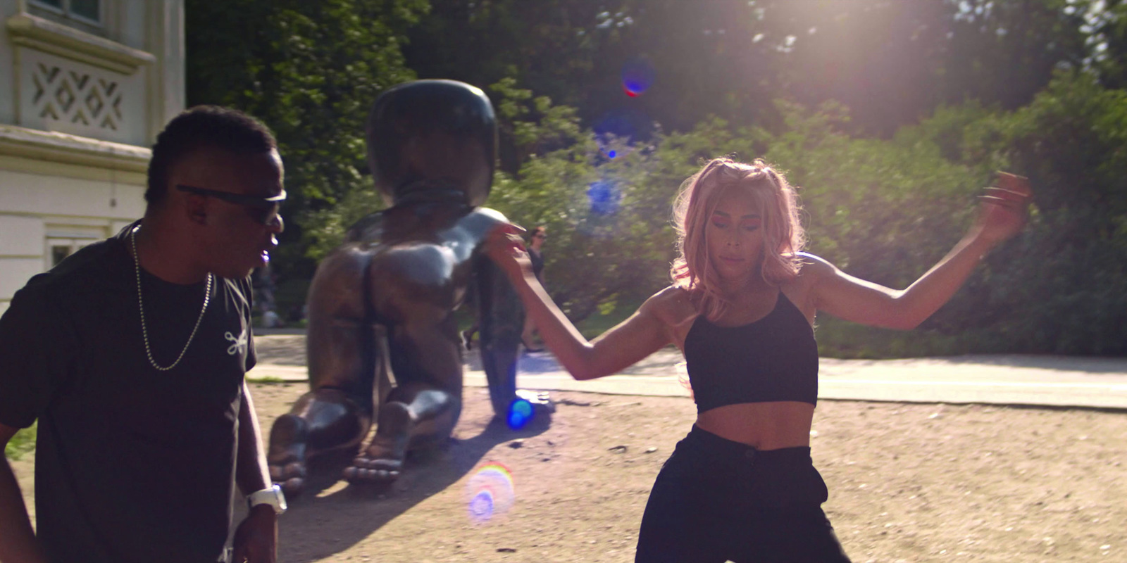 a man and a woman dancing in front of a statue