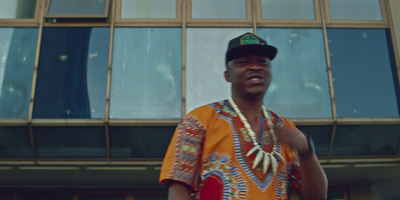 a man in a colorful shirt standing in front of a building