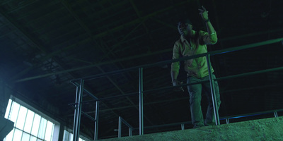 a man standing on a railing in a factory