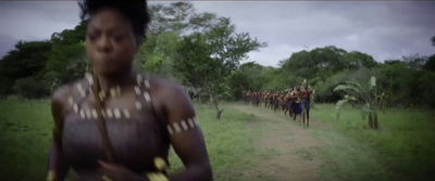 a group of people walking down a dirt road