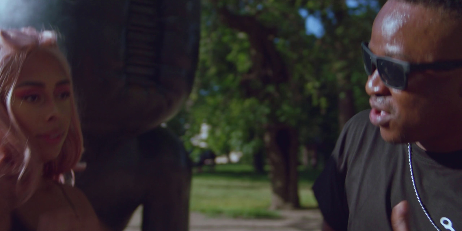 a man is talking to a woman in a park