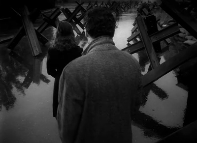 a man and a woman standing in a flooded area