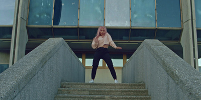 a girl with pink hair standing on stairs in front of a building