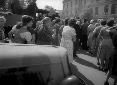 a crowd of people standing around a car