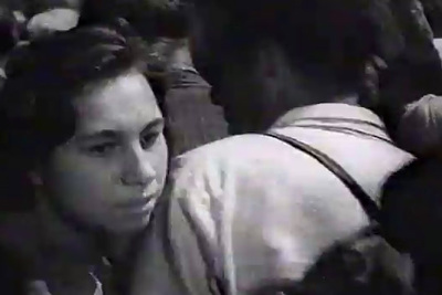 a black and white photo of a woman in a crowd