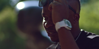 a man in a black shirt with sunglasses and a watch