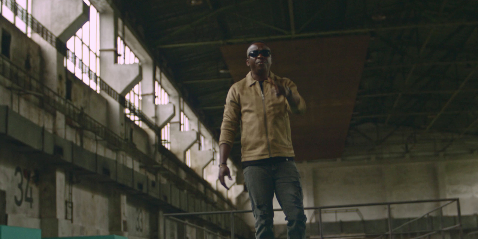 a man standing on a skateboard in a warehouse