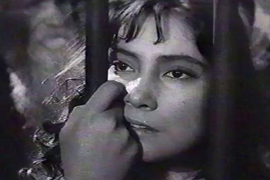 a black and white photo of a woman behind bars