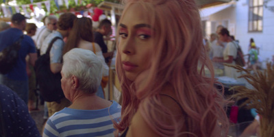 a woman with pink hair standing in a crowd