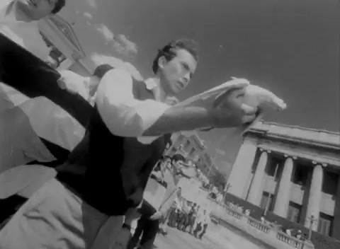 a man holding a bird in front of a building