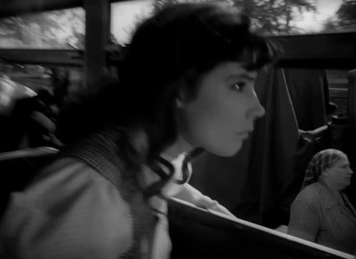 a black and white photo of a woman in a bus