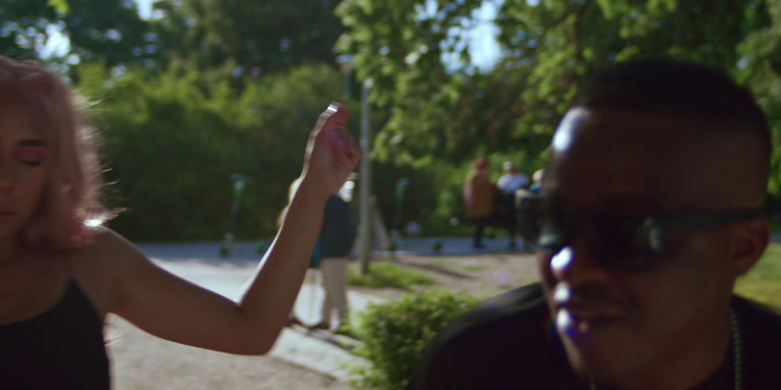 a man and a woman are standing in a park