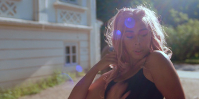 a woman with pink hair posing in front of a house