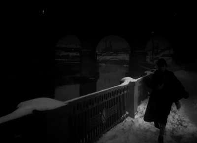 a person walking across a bridge in the snow