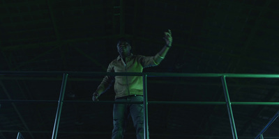 a man standing on a railing in a dark room