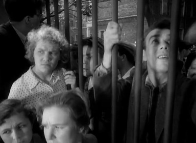 a black and white photo of people behind bars