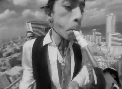 a black and white photo of a man smoking a cigarette