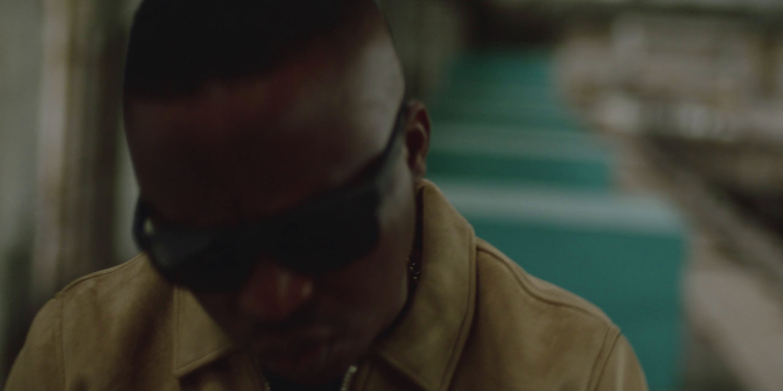 a man in sunglasses standing in a train station