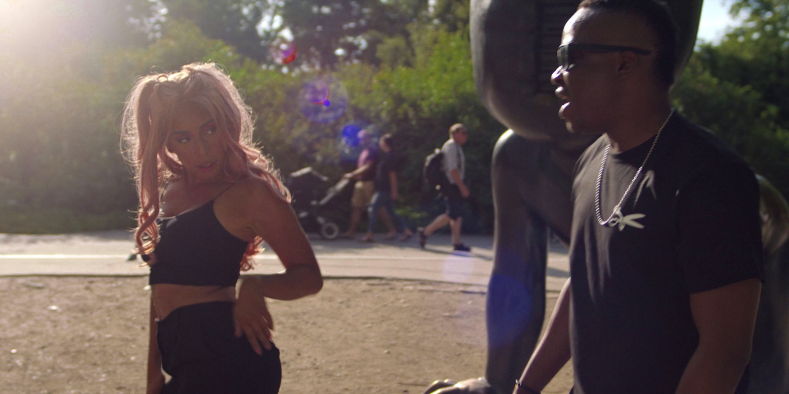 a man and woman standing next to each other in a park