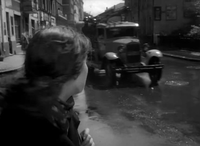 a black and white photo of people walking down a street