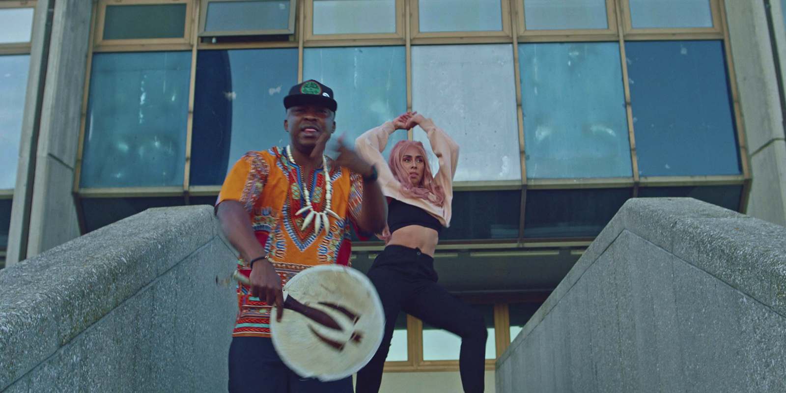 a man and a woman dancing on steps in front of a building