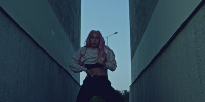 a woman with pink hair standing in a hallway