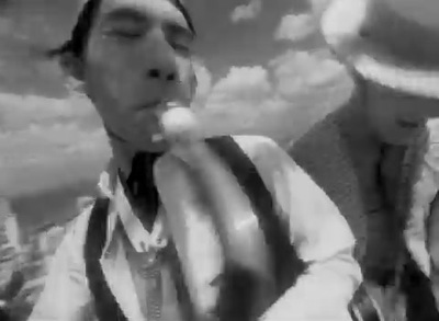 a black and white photo of a man blowing a bubble