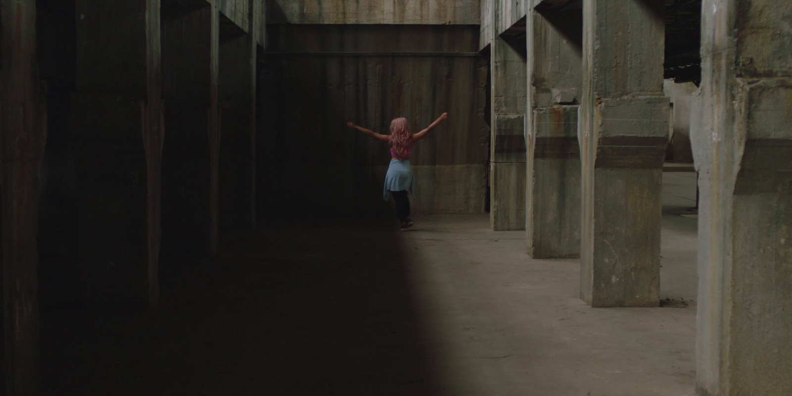 a girl is standing in a hallway with wooden beams