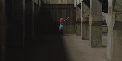 a girl is standing in a hallway with wooden beams