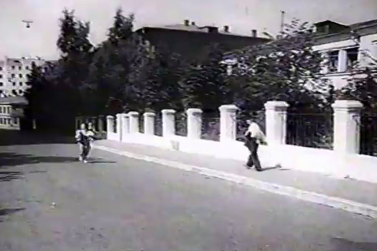 a black and white photo of people walking down a street