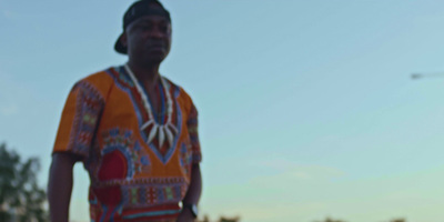 a man in a colorful outfit standing on a street